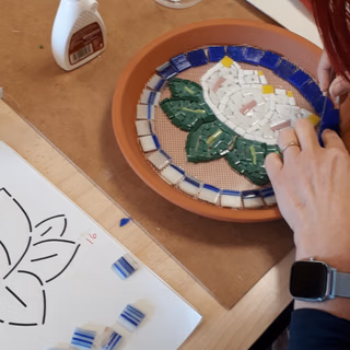 Une personne qui jointe son travail à la mosaïque