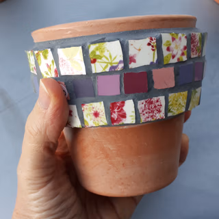 Une personne qui jointe son travail à la mosaïque