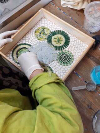 Une personne qui jointe son travail à la mosaïque