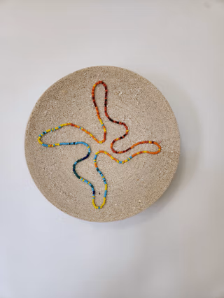 Une personne qui jointe son travail à la mosaïque