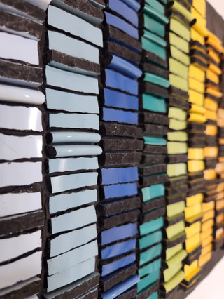 Une personne qui jointe son travail à la mosaïque